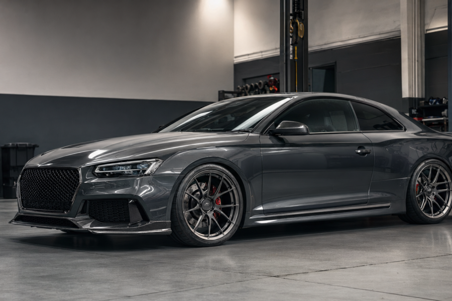 Modified European performance coupe with forged wheels and lowered suspension inside a Gold Coast tuning workshop