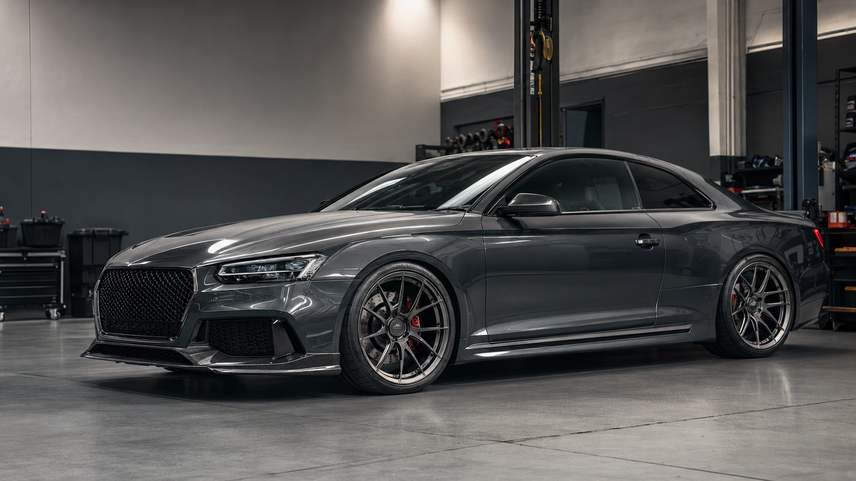 Modified European performance coupe with forged wheels and lowered suspension inside a Gold Coast tuning workshop